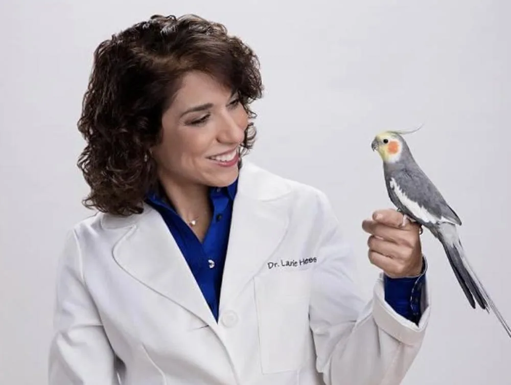 Dr Laurie Hess with cockatiel perched on finger